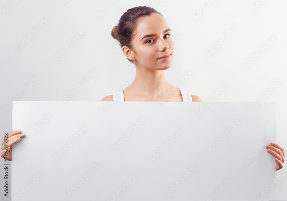 Portrait of a beautiful brunette woman holding a white blank banner. Portrait of a beautiful brunette woman holding a white blank banner.