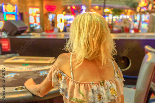 Photography Caucasian blonde woman gambling in casino sitting at blackjack table