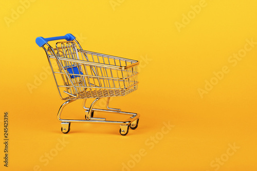 Close up retail shopping cart over yellow