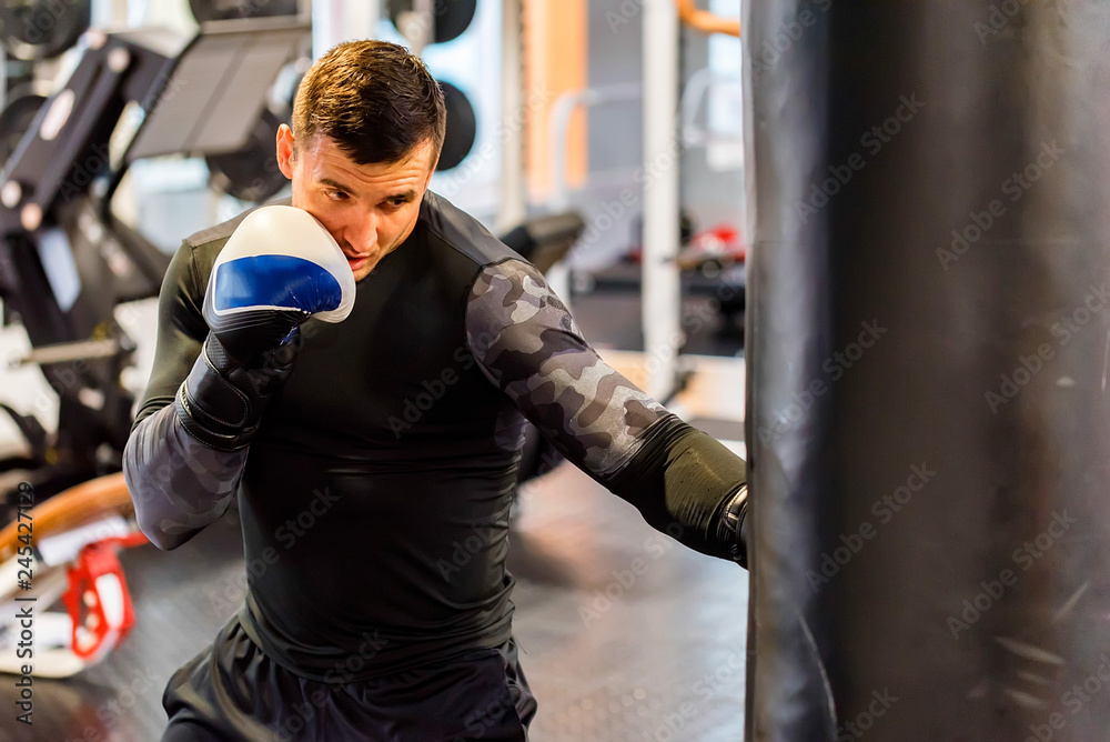 Male boxer does uppercut in modern gym Male boxer does uppercut in modern gym