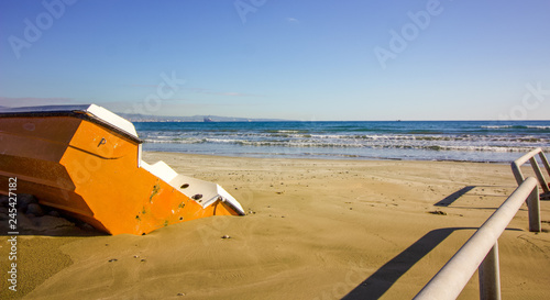 Orange boat in the sands of the winter beach waiting for the summer months to arrive, Cyprus