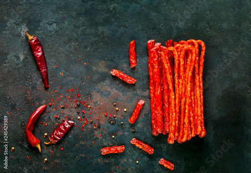 smoked sausages with spices on vintage rusty metal background, organic food concept, copy space, closeup, flat lay, 