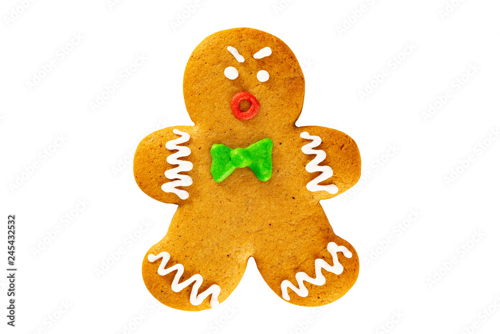 Closeup angry xmas gingerbread man cookie with a bowtie isolated at white background. Closeup angry xmas gingerbread man cookie with a bowtie isolated at white background.