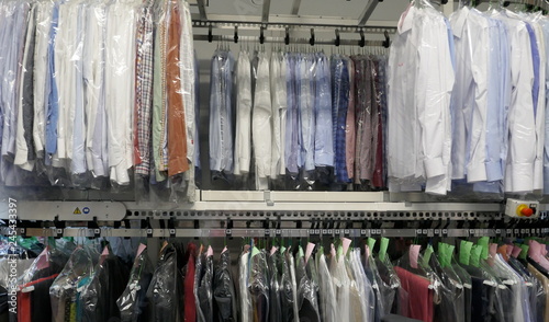 Freshly cleaned men's shirts and ladies blouses
in a textile cleaning, hanging on hangers and packed in plastic wrap
