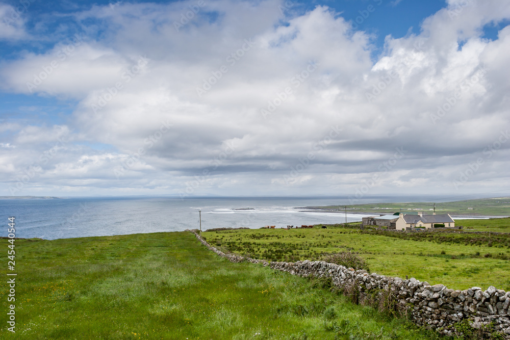Houses in Burren region in County Clare, Ireland with Atlantic Ocean in the distance