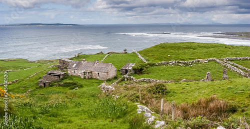 Abandoned houses located in Burren region in County Clare, Ireland with Ocean in the distance