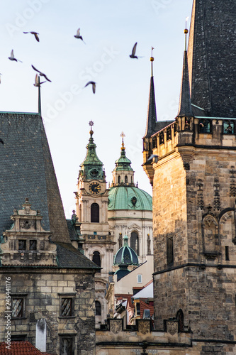 (Lesser Town of Prague) through the arch of the Malostransky tower. View of colorful old town. Prague with St. Nicholas Church, Mala Strana Vertical shot photo