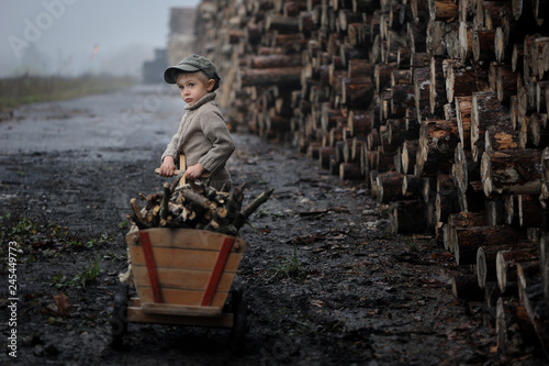 A sad child,  worker, work hard in a sawmill, social injustice, difficulties to overcome. Beautiful portrait of a boy, deep, emotional.