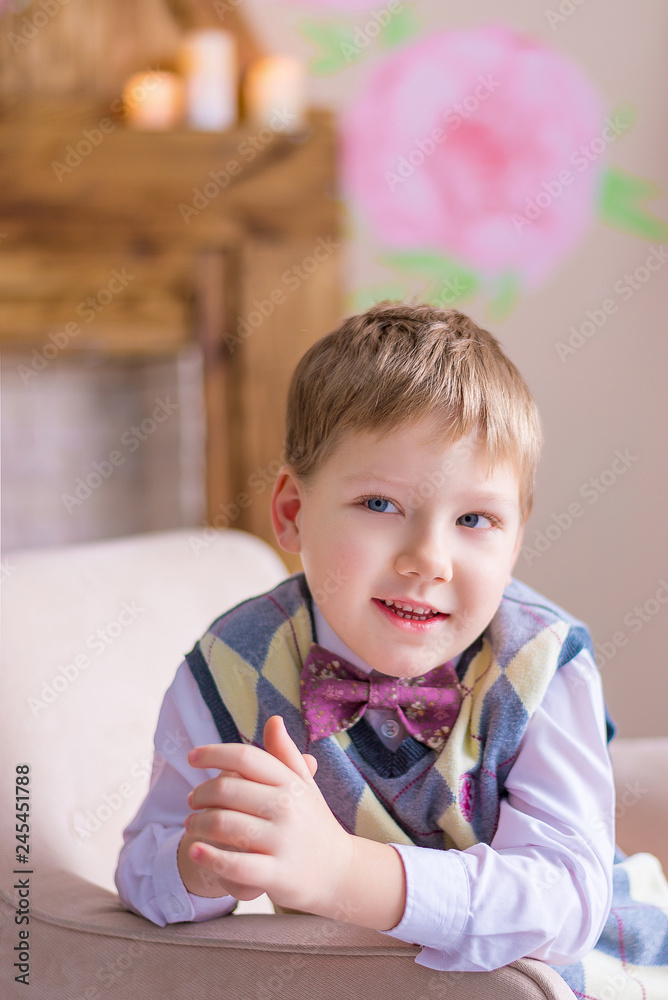 Fototapeta premium Funny boy sitting on the armchair