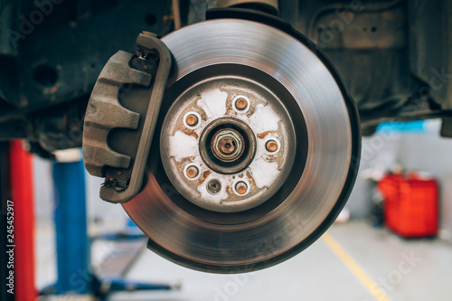Close up of car disc brake during the wheel tire change or repair. Disc brake of the car during the maintenance at auto service garage. 