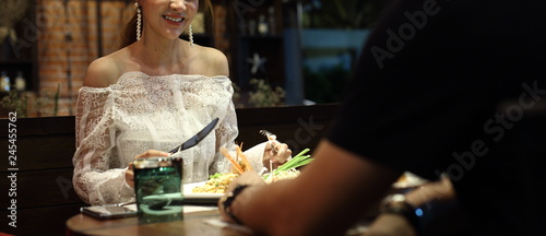 Woman white lace dress have dinner in restaurant with low light candle waiting for lover to join celebrate anniversary night together but come so late and feel bad, copy space photo