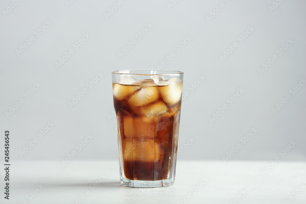 Glass of refreshing cola with ice cubes on table Glass of refreshing cola with ice cubes on table
