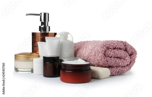 Different body care products and towel on white background