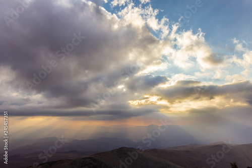 Sunset at "La Silla" Observatory, North Chile, a view above the horizon line with the ray of light coming from the Sun passing the clouds layers an impacting the Chilean countryside and awe landscape