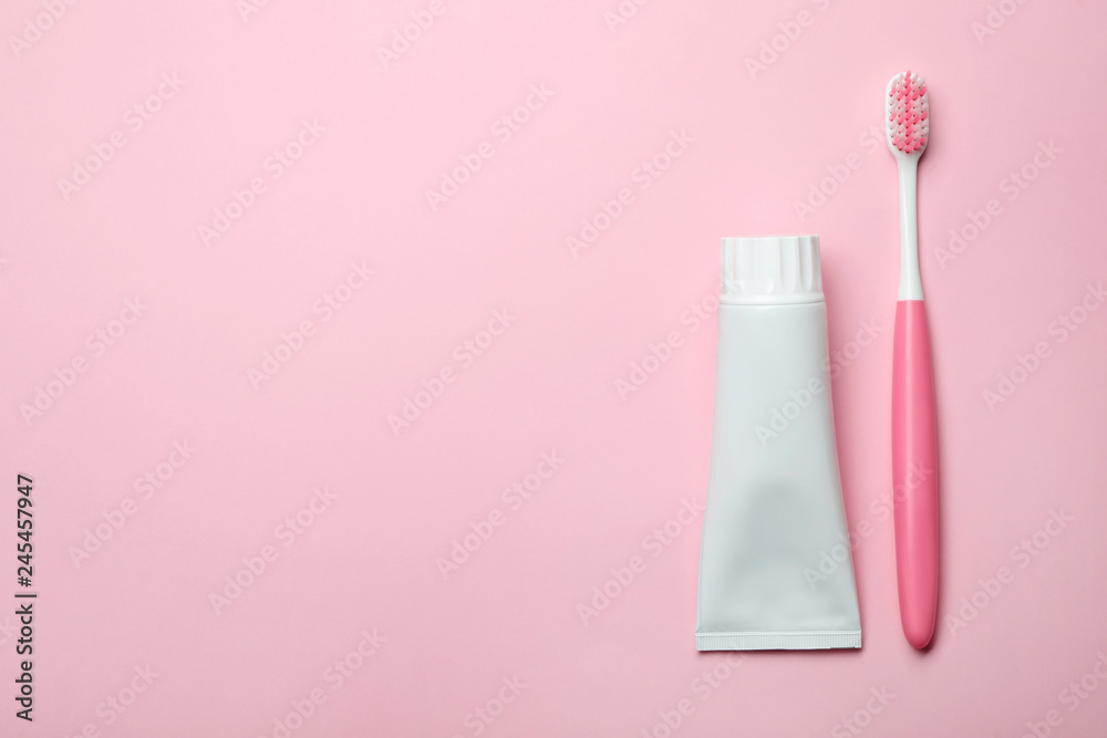 Blank tube of toothpaste and brush on color background, top view with space for text
