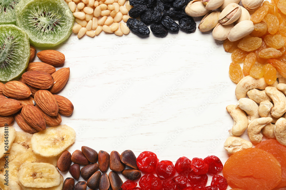 Frame of different dried fruits and nuts on wooden background, top view. Space for text Frame of different dried fruits and nuts on wooden background, top view. Space for text