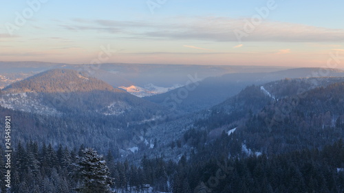 Sunrise over snowy Black Forest hills. Snowy pine tree forest.Sunrise in snowy hills.