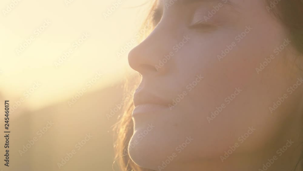 close up portrait of beautiful woman enjoying peaceful sunset exploring spirituality looking up praying contemplating journey with wind blowing hair