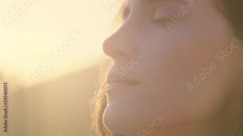 close up portrait of beautiful woman enjoying peaceful sunset exploring spirituality looking up praying contemplating journey with wind blowing hair