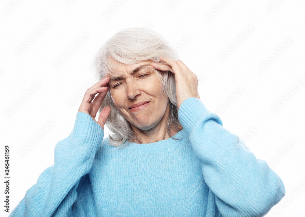 Lifestyle, health and people concept: senior lady having headache over white background Lifestyle, health and people concept: senior lady having headache over white background