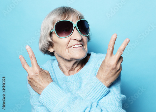 Old woman laugh and showing peace or victory signat camera Fototapet