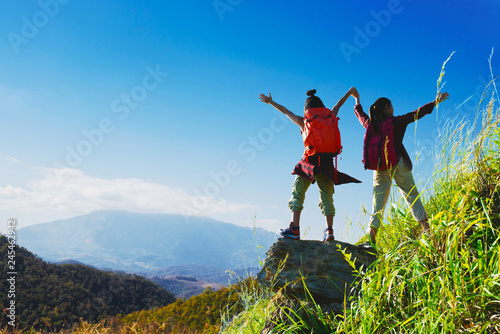 Two female hikers enjoying on the top of cliff mountian.