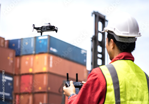 Fotografi Foreman piloting drone at containers port , Business logistic concept, import and export concept