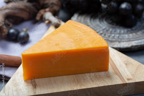 Piece of hard orange Cheddar cheese close up