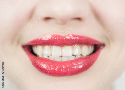 White teeth and red lipstick on the lips. Beautiful mouth. Charming woman s smile. Dental care and Stomatology concept. Girl is very happy.