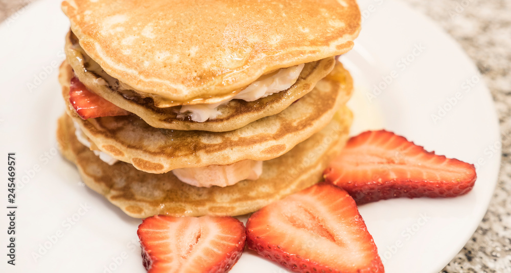 Freshly prepared traditional pancakes with strawberries. Delicious homemade breakfast. Sweet food.