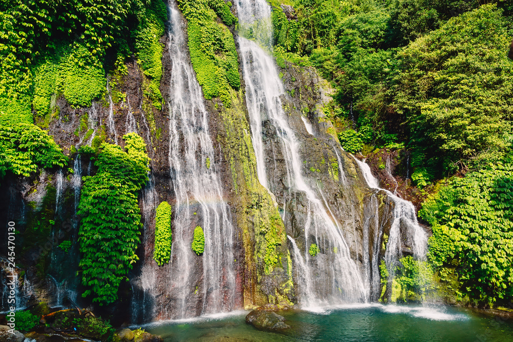 Fototapeta premium Waterfall with crystal water and rainbow in tropical island. Bali, Indonesia