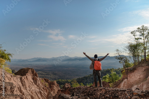 Tourist on the peak of high rocks. Sport and active life concept