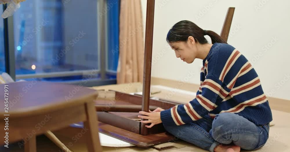 Woman assembling a table Woman assembling a table
