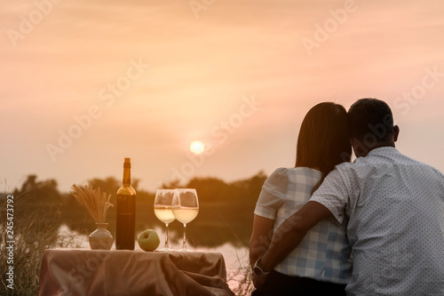 Happy life moments. Couple enjoying the sunset while having a glass of wine