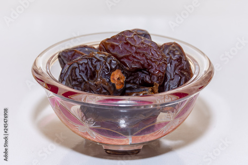 A bowl of medjool dates from Saudi Arabia on a white background for Ramadan.  photo