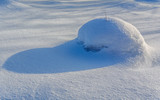Snow hat on a hummock with a shadow (view 2)