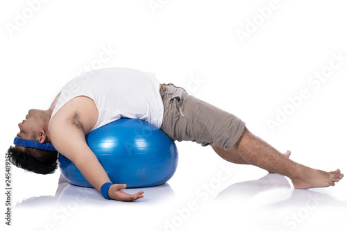 portrait of fat young men do pilates with a lying down relaxed