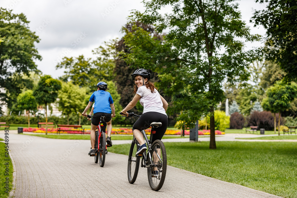 Healthy lifestyle - people riding bicycles in city park