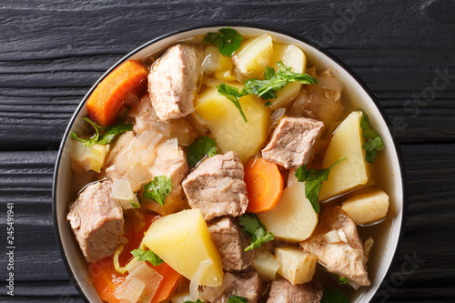 German soup Pichelsteiner or Bismarck stew with vegetables and three kinds of meat close-up in a bowl. horizontal top view