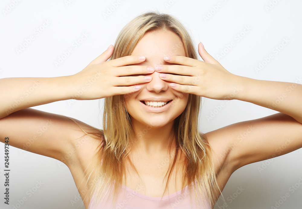teen girl with her hands covering her eyes.