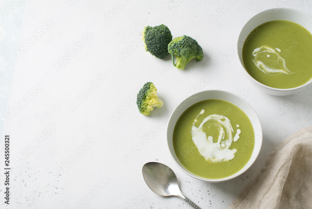 Green vegetable broccoli soup on white background minimalism