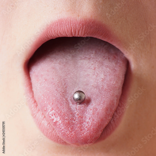 close-up of a female mouth with tongue piercing photo