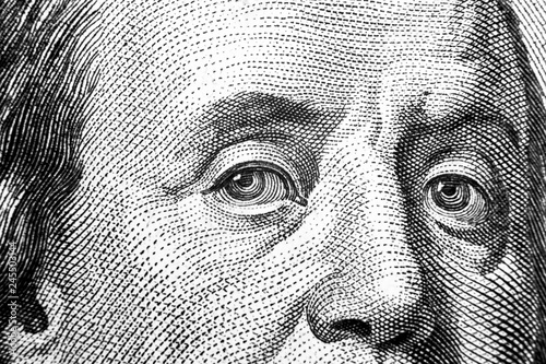 Close up view Portrait of Benjamin Franklin on the one hundred dollar bill. Background of the money. 100 dollar bill with Benjamin Franklin eyes macro shot. Black and white photo