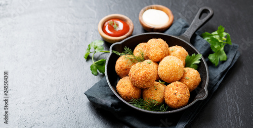 Potato croquettes - mashed potatoes balls breaded and deep fried, served with different sauce. photo