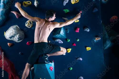 Wallpaper Mural Successful self confident muscle healthy winner climber mountaineer alpinist man male bouldering training in climbing wall. Achieved top of wall in complex competition. Success and healthy lifestyle Torontodigital.ca