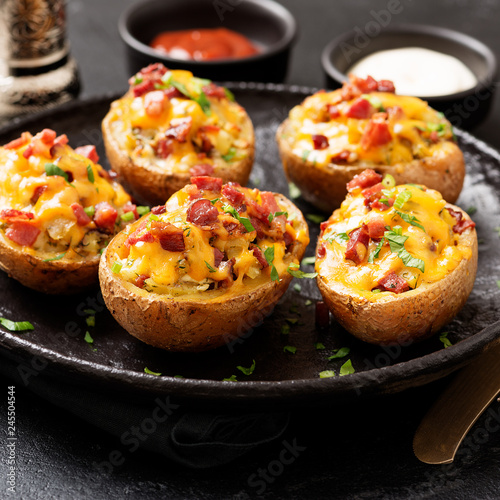 Billede på lærred Hot baked potato topped with bacon, green onions and cheddar cheese