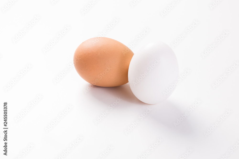 brown and white egg side by side on white background with shadow brown and white egg side by side on white background with shadow