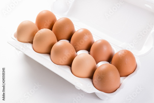 ten brown eggs in white package side view close-up