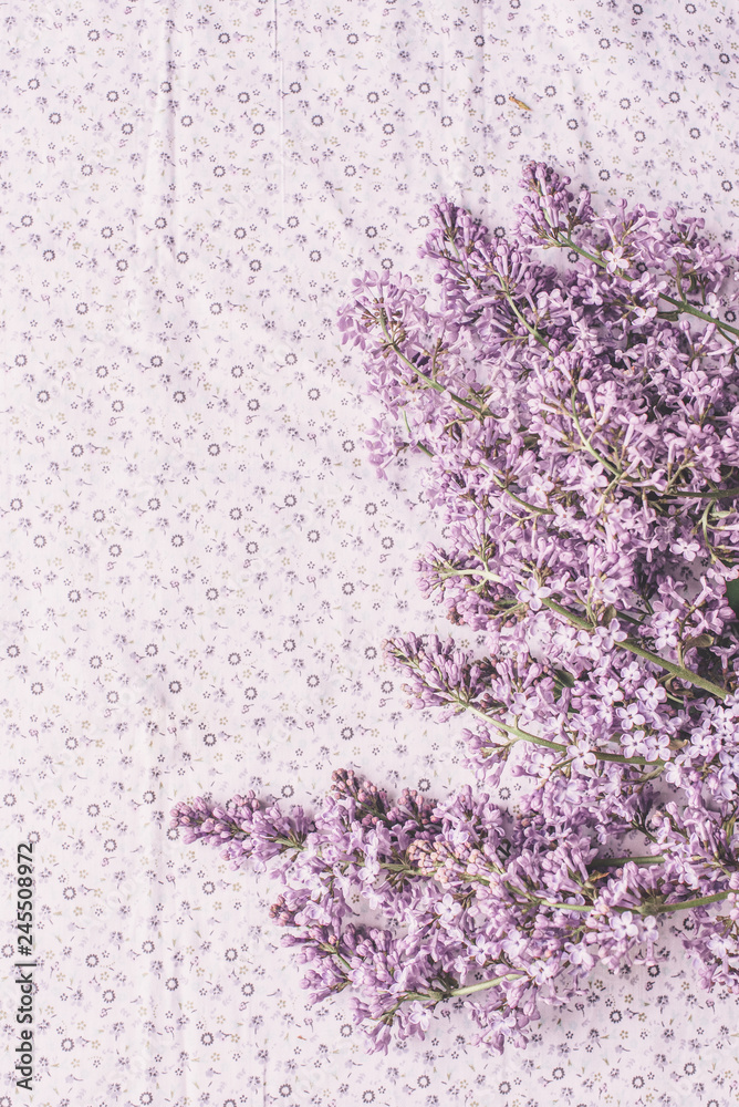 Spring flowers. Lilac flowers petals on white fabric background. Top view, flat lay Spring flowers. Lilac flowers petals on white fabric background. Top view, flat lay