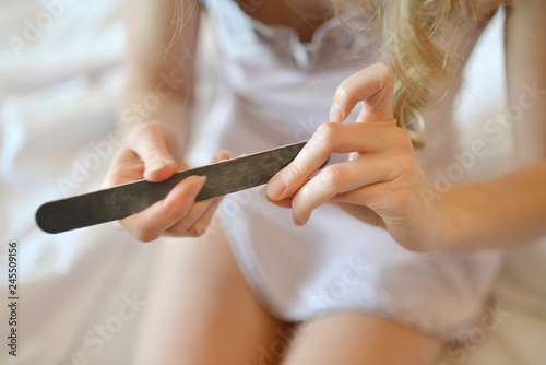 Woman using nailfile during making menicure herself